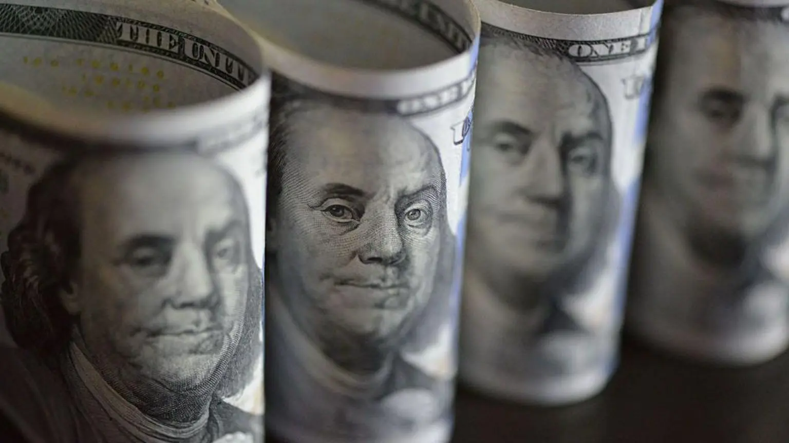 Чотири банкноти доларів США, видно згорнутими навпіл
