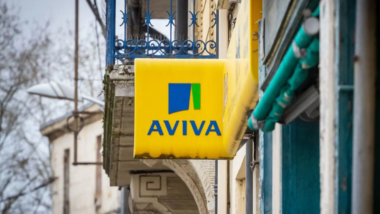 Жовті написи Aviva висять біля будівлі в день сірого лижа