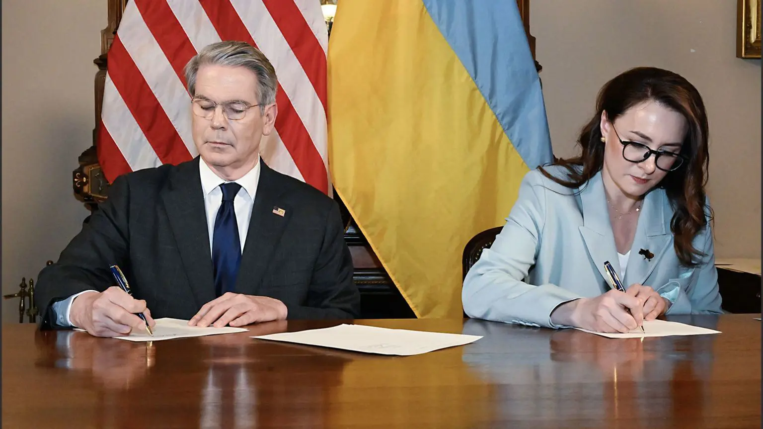 Міністр фінансів США Скотт Бессант (ліворуч) і перший віце-прем'єр-міністр України Юлія Свириденко (праворуч) підписують угоду про природні ресурси
