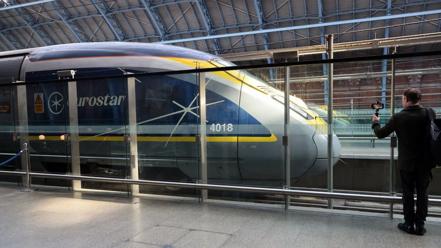 Чоловіка, який стоїть біля трамвая Eurostar на лондонському вокзалі Сент-Панкрас