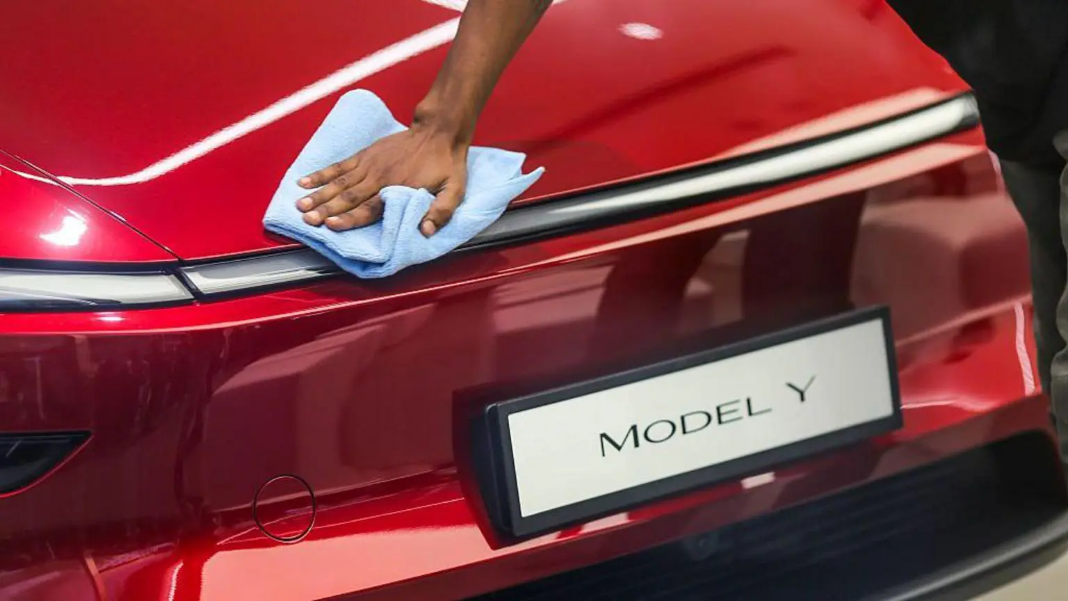 Робітник чистить електромобіль Tesla Model Y у щойно відкритому магазині Tesla Inc. у комплексі Bandra Kurla (BKC) у Мумбаї, Індія, у вівторок, 15 липня 2025 р.
