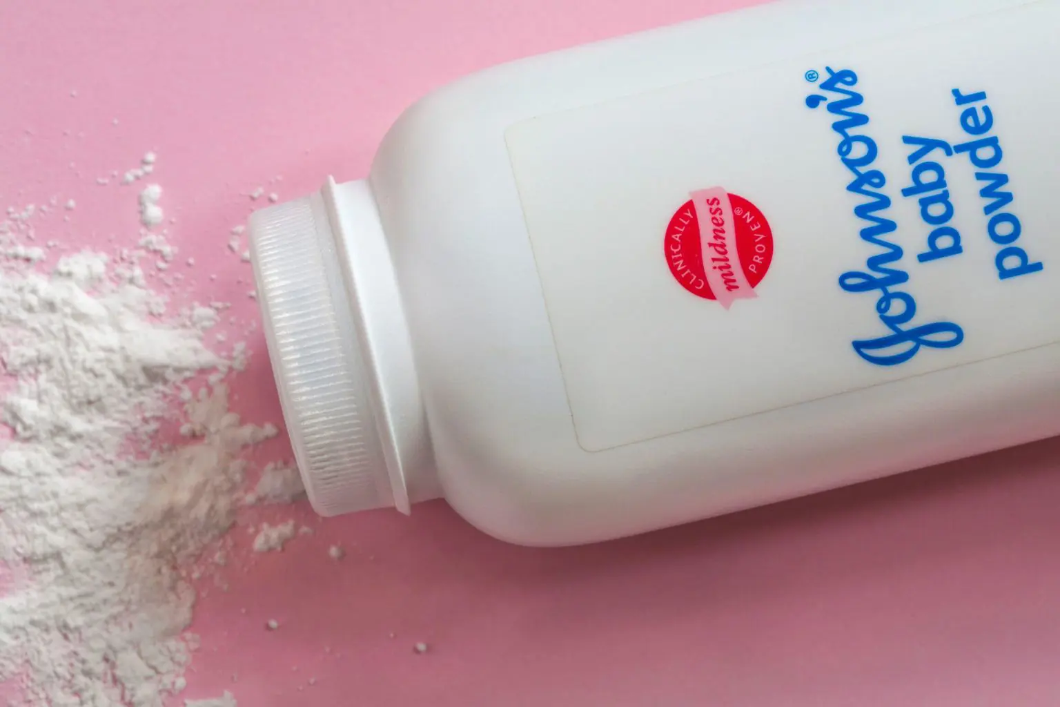 Дитяча присипка Johnson's - Дитяча присипка Johnson & Johnson з розлитим вмістом на рожевому фоні