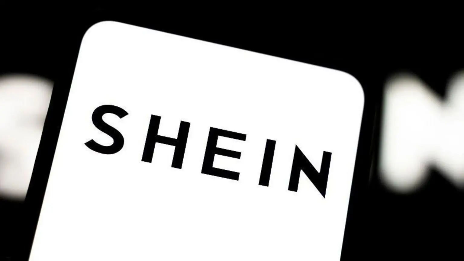 Чорний логотип Shein на білому фоні на екрані смартфона