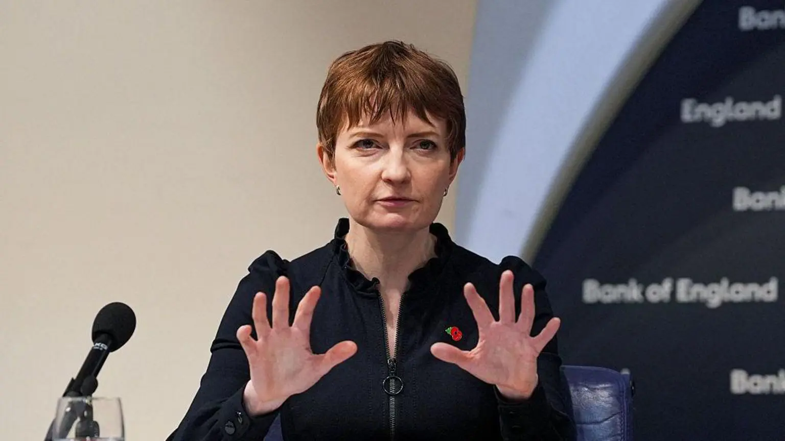 Заступниця голови Банку Англії Клер Ломбарделлі виступає на прес-конференції та жестикулює обома руками, коли говорить.