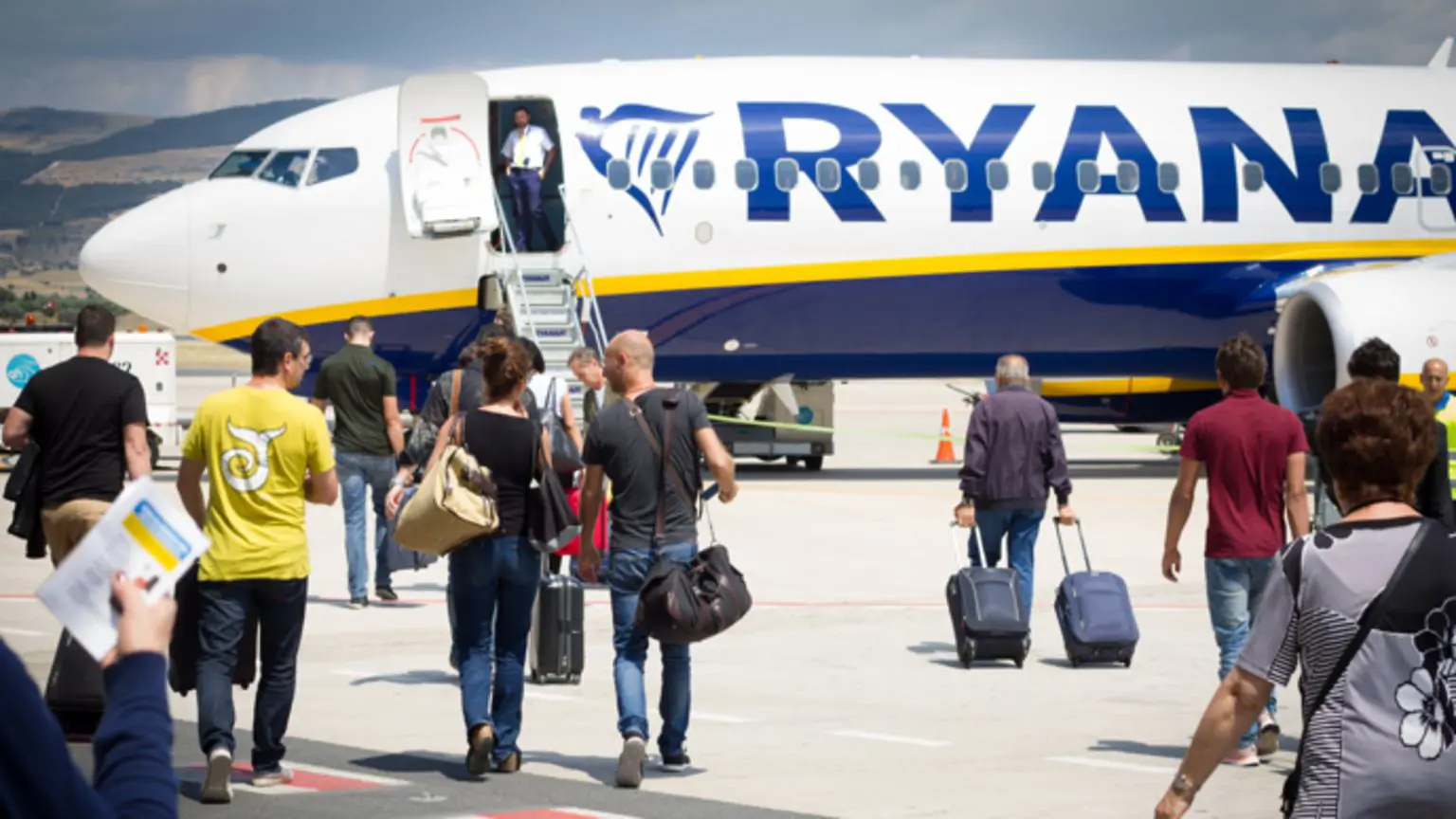 Пасажири прямують до літака Ryanair на злітно-посадковій смузі