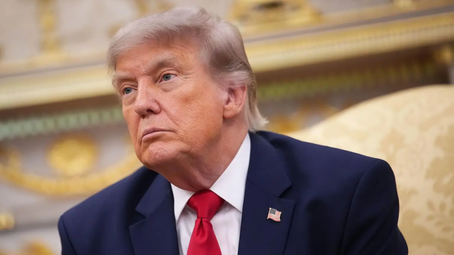 Президент Дональд Трамп у блейзері, білій сорочці та червоній краватці.
