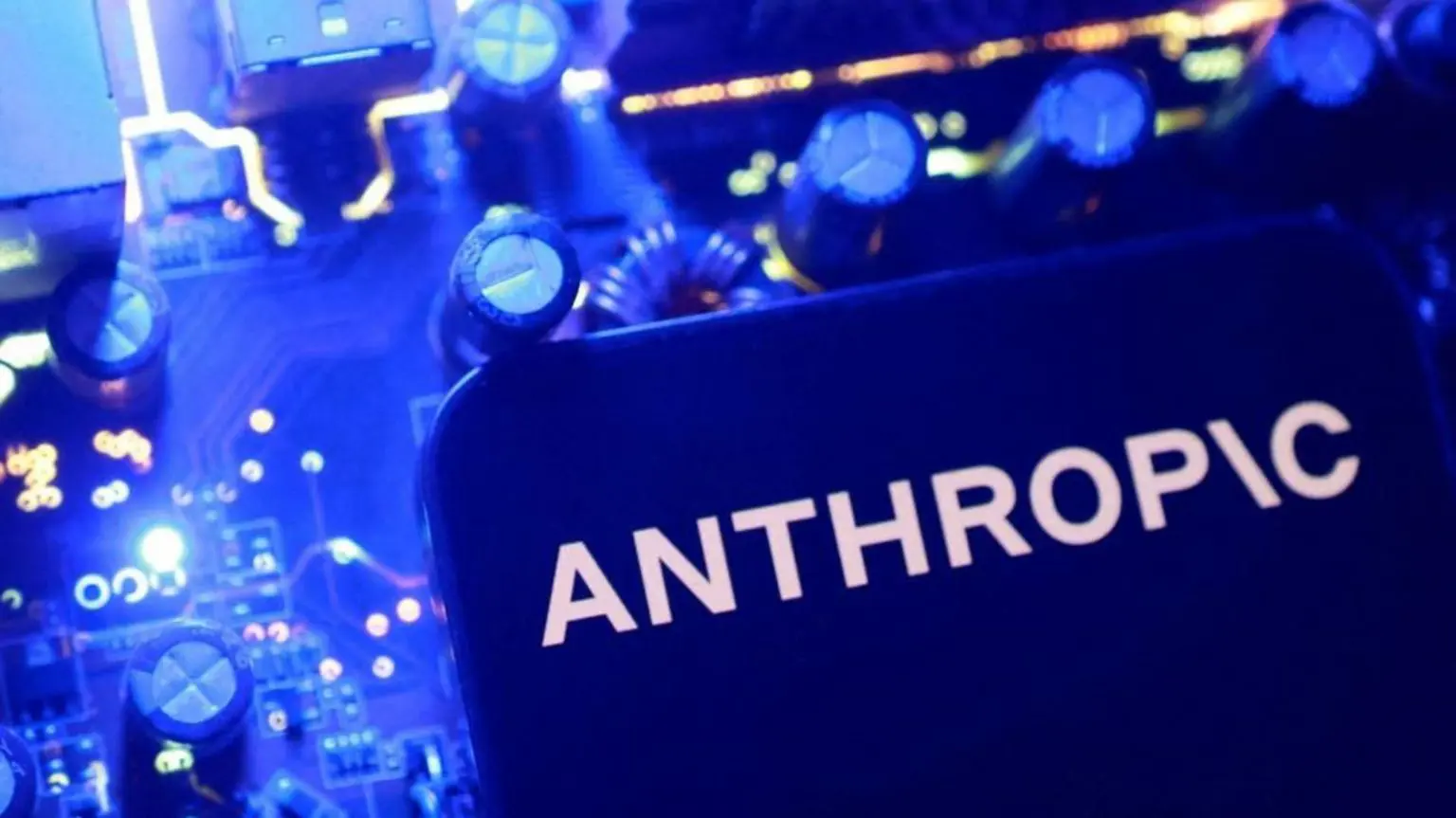 Синій логотип Anthropic на плоскій поверхні з синіми ручками та циферблатами на задньому плані.
